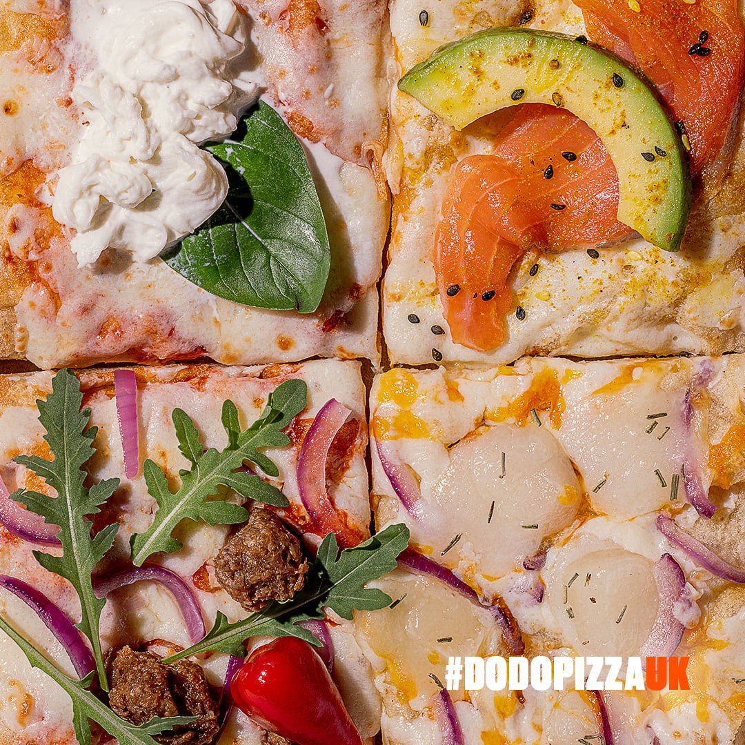 Close-up of four Roman-style pizza slices with burrata, salmon and avocado, vegan chorizo and scallops, tagged #DODOPIZZAUK