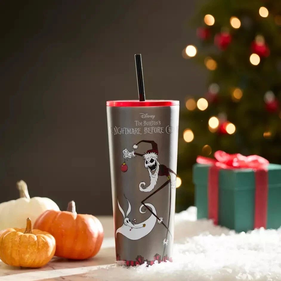 The Nightmare Before Christmas tumbler with Santa Jack and Zero, next to pumpkins and a Christmas tree