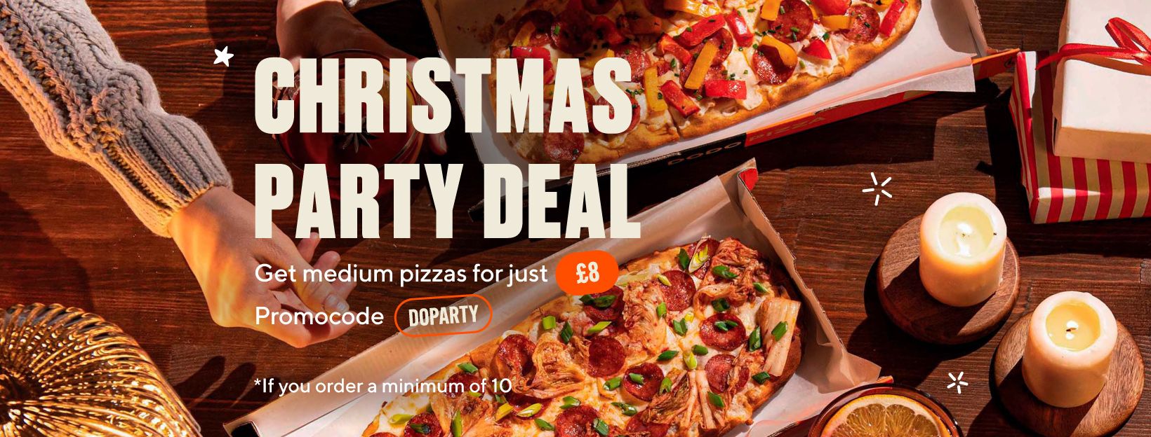Christmas Party Deal banner: two long pizzas in boxes on a wooden table with candles and presents, “Get medium pizzas for just £8”, promo code DOPARTY