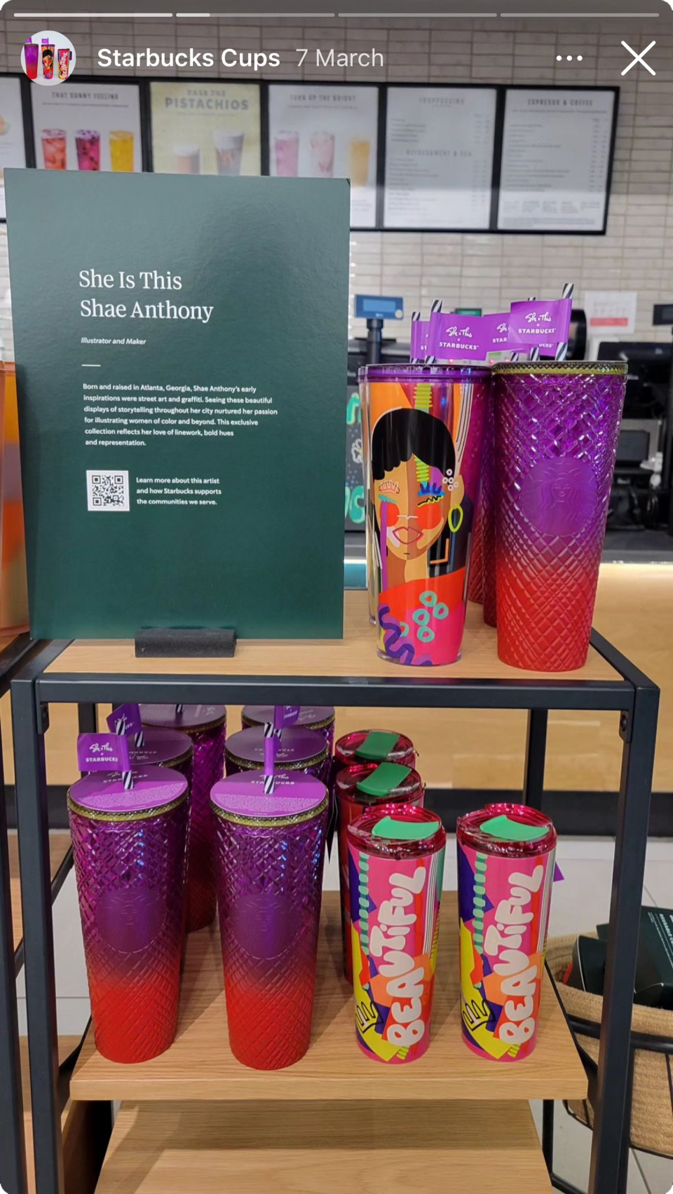 Store display of the “She Is This” collection by artist Shae Anthony: a sign and shelves of colourful cold cups